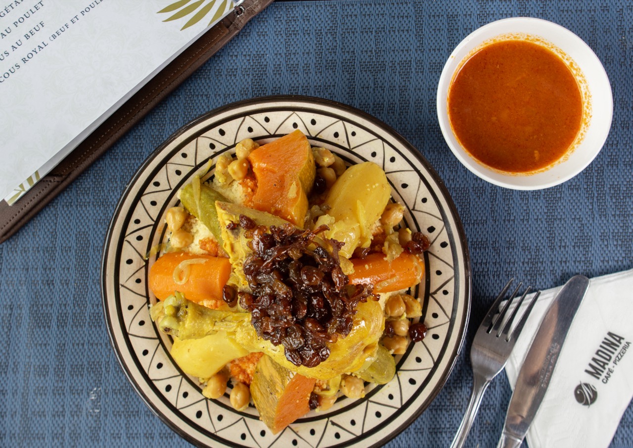 Couscous marocain garni d'oignons caramélisés, servi sur une table